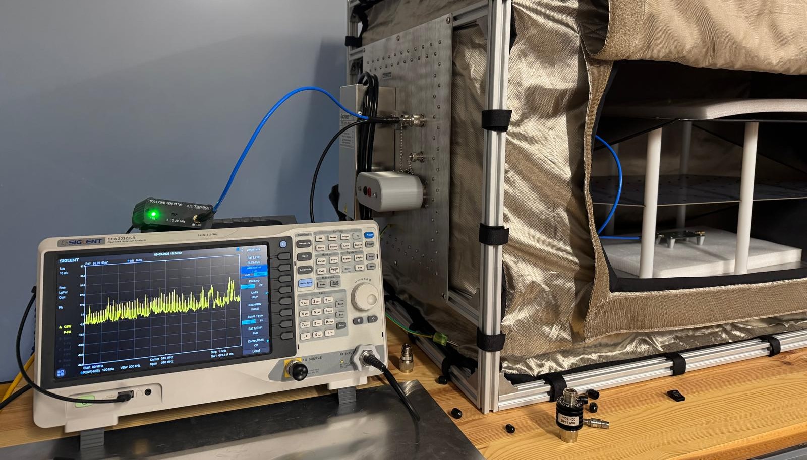 Test setup: spectrum analyzer, comb generator, shielded tent with TEM cell — tent open for the photo